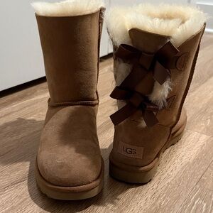 Brand new Never Worn UGG Tan Sheepskin Boots with Ribbon Accents